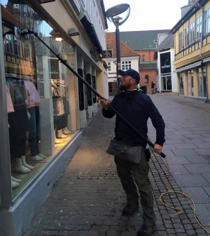 Morten Hein pudser vinduer i en gågade
