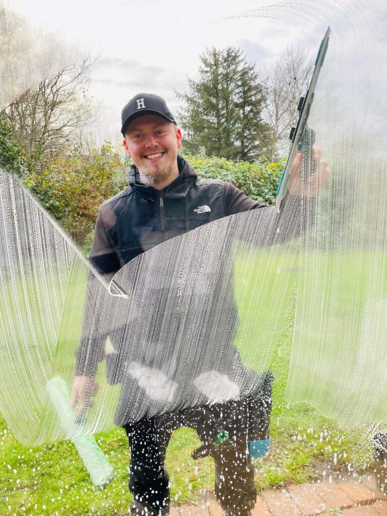 Glad vinduespudser rengør vindue udendørs